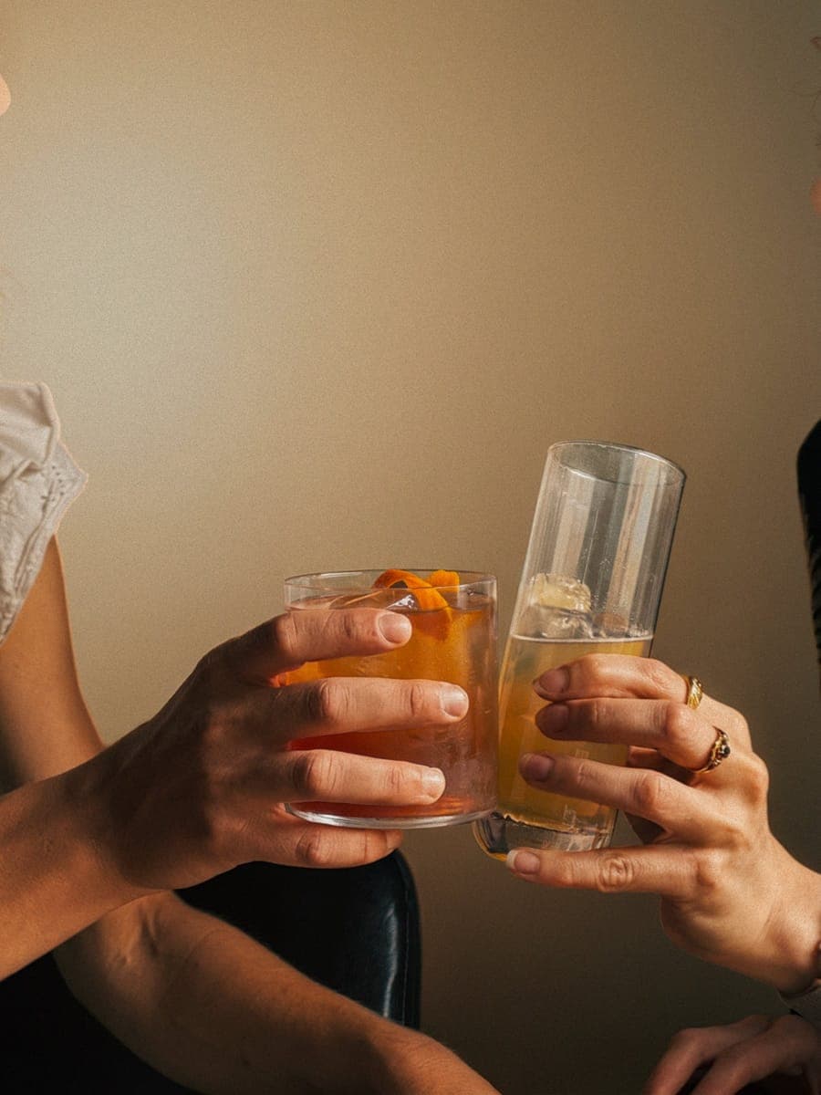 Two glasses meeting in a toast