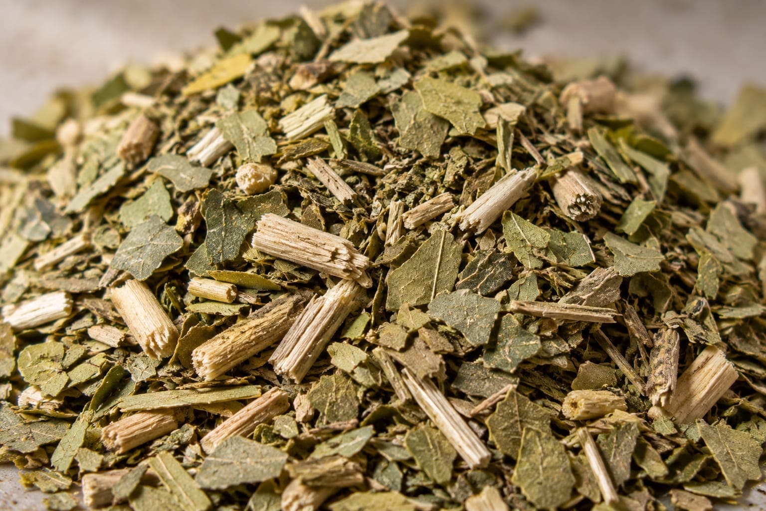Cut yerba mate: fragments of dried leaf and pale pieces of palo, the stem.